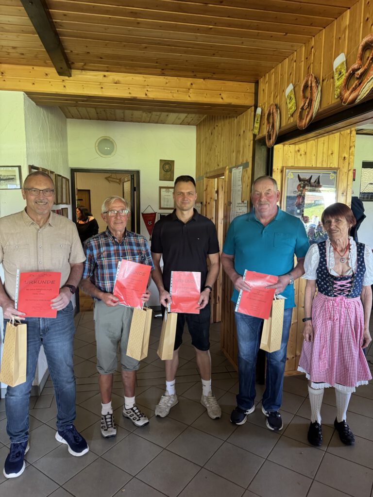 Gruppenfoto im Vereinsheim mit Urkunden und Geschenktaschen.